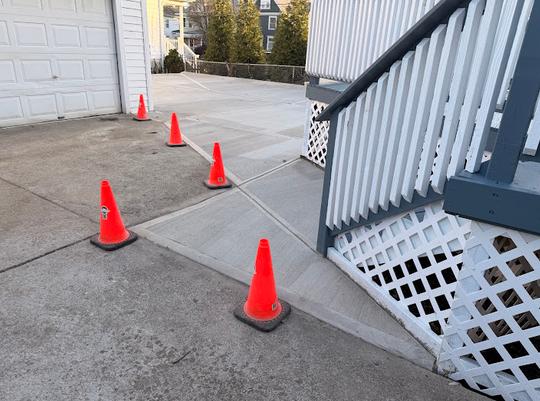 Concrete walkway connected with a patio and driveway.