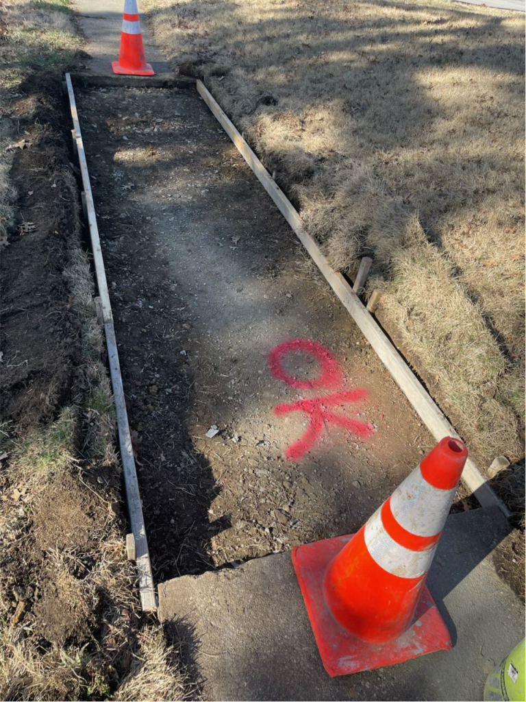 Concrete workers completing a sidewalk project at a Cincinnati property