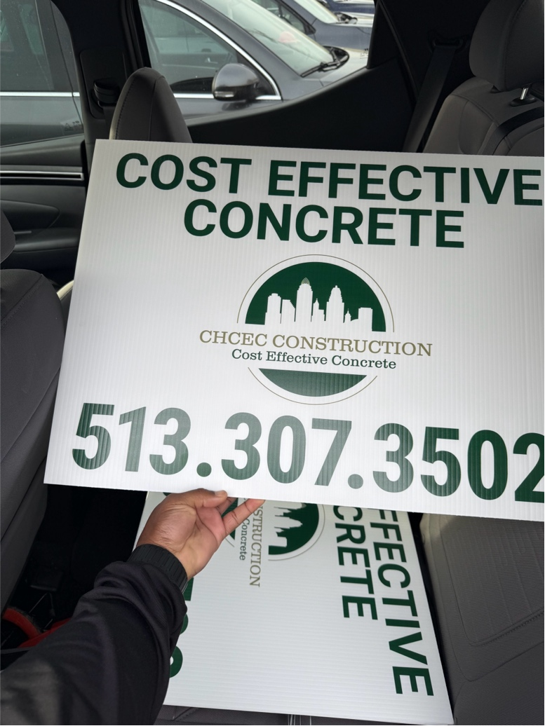 Worker holding a Cost Effective Concrete board with company contact information